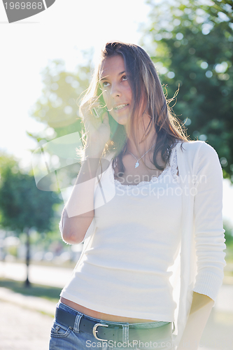 Image of young woman talk by cellphone on street