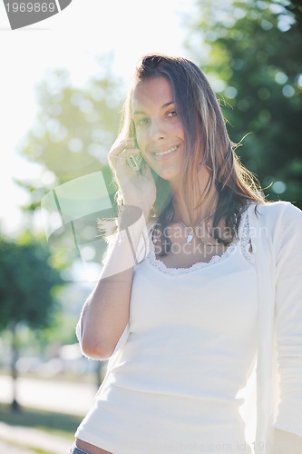 Image of young woman talk by cellphone on street