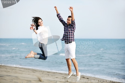 Image of happy young couple have fun on beach