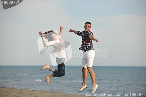 Image of happy young couple have fun on beach
