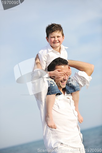 Image of happy father and son have fun and enjoy time on beach