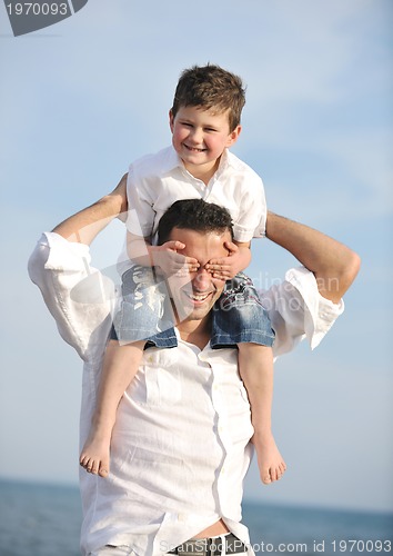 Image of happy father and son have fun and enjoy time on beach