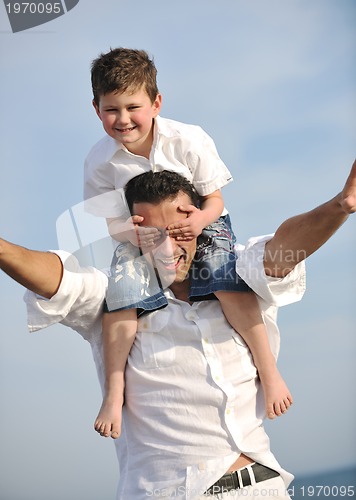 Image of happy father and son have fun and enjoy time on beach