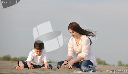 Image of mom and son relaxing on beach