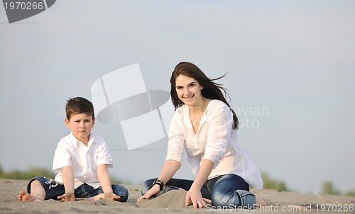 Image of mom and son relaxing on beach