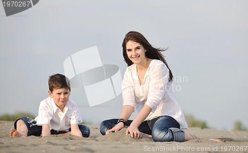 Image of mom and son relaxing on beach