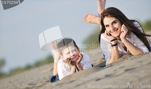 Image of mom and son relaxing on beach