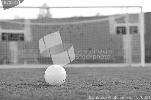 Image of Soccer ball on grass at goal and stadium in background