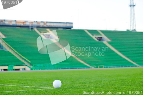 Image of Soccer ball on grass at goal and stadium in background