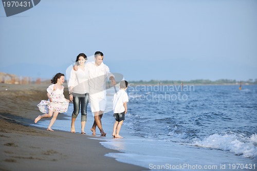 Image of happy young family have fun on beach at sunset
