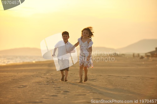 Image of happy young family have fun on beach at sunset