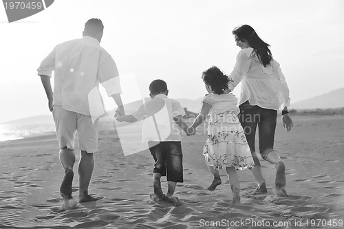 Image of happy young family have fun on beach at sunset