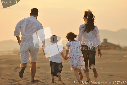 Image of happy young family have fun on beach at sunset