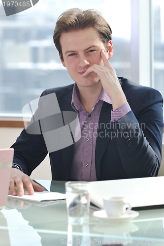 Image of young business man alone in conference room