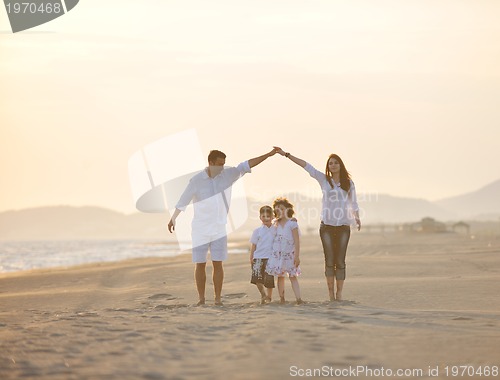 Image of happy young family have fun on beach at sunset