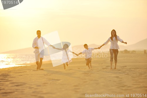 Image of happy young family have fun on beach at sunset