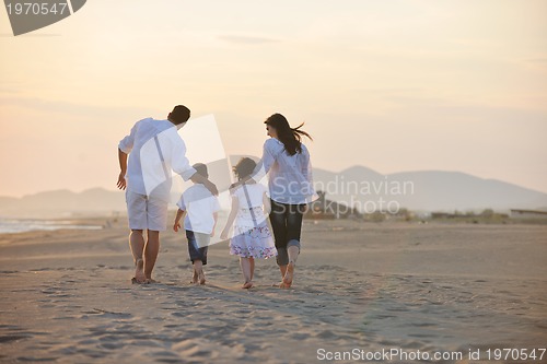 Image of happy young family have fun on beach at sunset