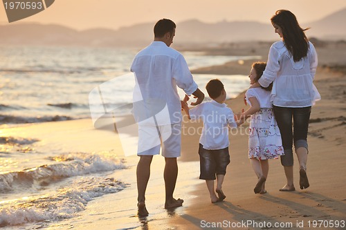 Image of happy young family have fun on beach at sunset
