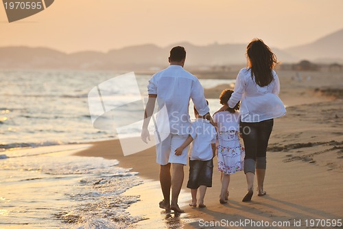 Image of happy young family have fun on beach at sunset