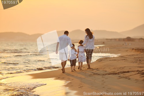 Image of happy young family have fun on beach at sunset