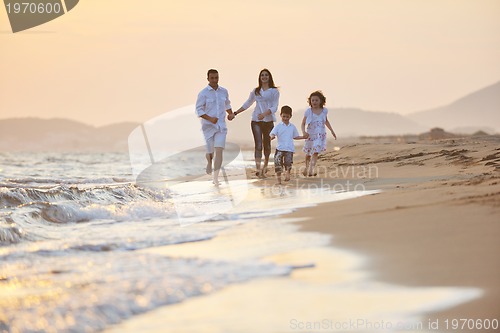 Image of happy young family have fun on beach at sunset