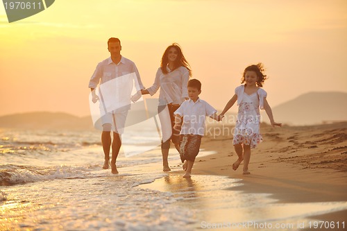 Image of happy young family have fun on beach at sunset