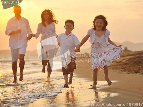 Image of happy young family have fun on beach at sunset