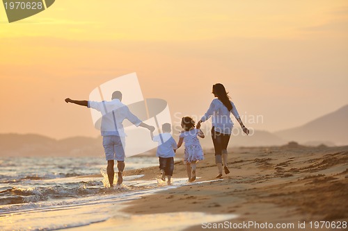 Image of happy young family have fun on beach at sunset