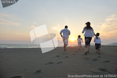 Image of happy young family have fun on beach at sunset