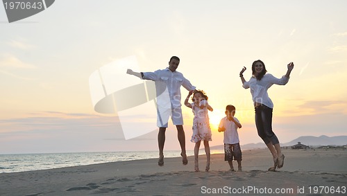 Image of happy young family have fun on beach at sunset