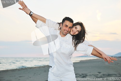 Image of happy young couple have fun on beach