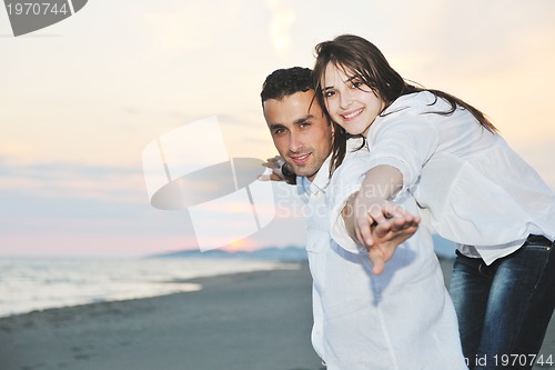 Image of happy young couple have fun on beach