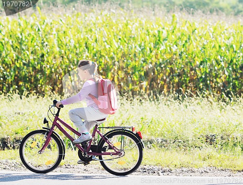 Image of schoolgirl traveling to school on bicycle