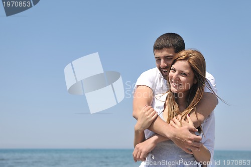 Image of happy young couple have fun on beach