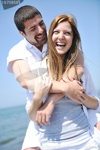 Image of happy young couple have fun on beach