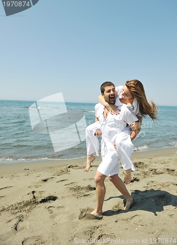 Image of happy young couple have fun on beach