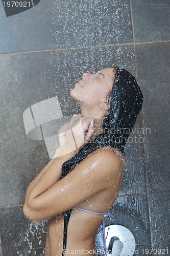 Image of sexy young woman enjoing bath under water shower