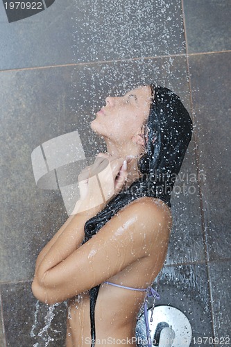 Image of sexy young woman enjoing bath under water shower