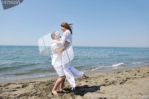 Image of happy young couple have fun on beach