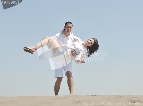 Image of happy young couple have fun on beach