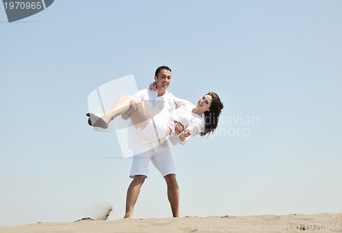 Image of happy young couple have fun on beach