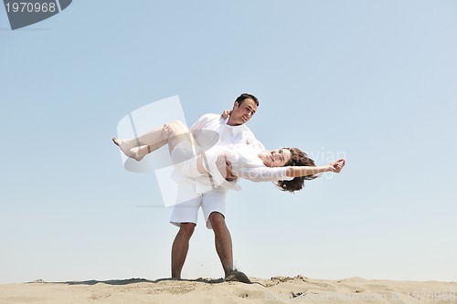 Image of happy young couple have fun on beach