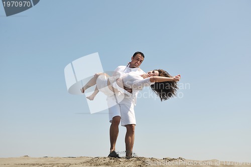 Image of happy young couple have fun on beach
