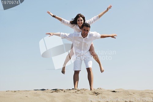 Image of happy young couple have fun on beach