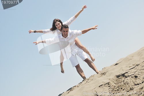 Image of happy young couple have fun on beach