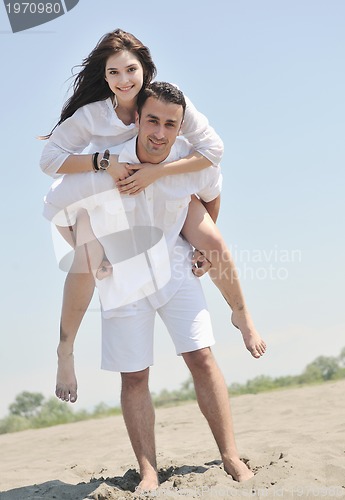 Image of happy young couple have fun on beach