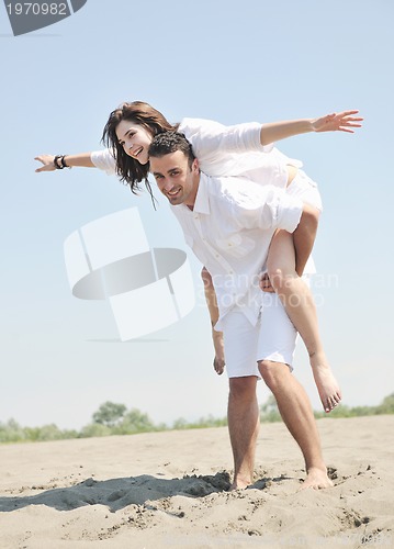 Image of happy young couple have fun on beach