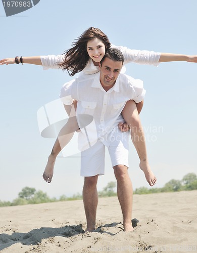 Image of happy young couple have fun on beach