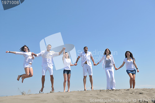Image of happy people group have fun and running on beach