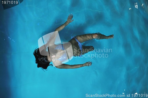 Image of pretty young lady  relaxing in the swimming pool